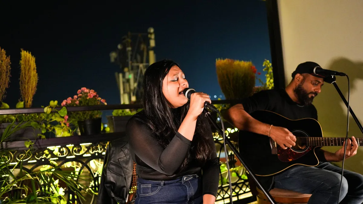 Live acoustic set on the Levitate rooftop — singer and guitarist under the night sky