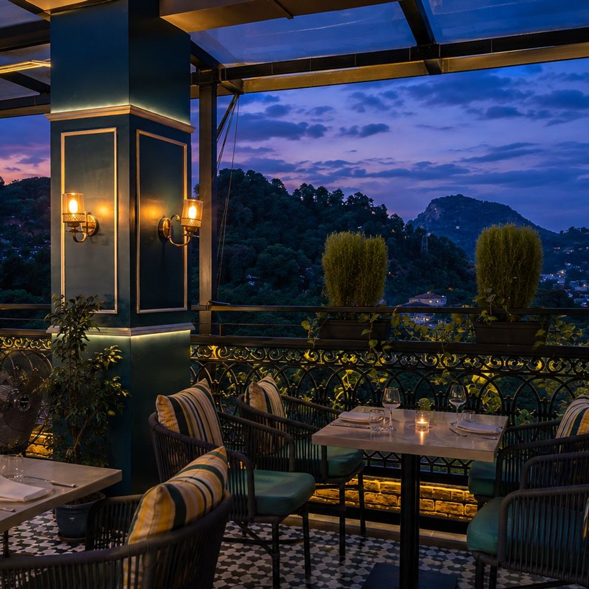 Open-air terrace at dusk, Guwahati skyline beyond the rail