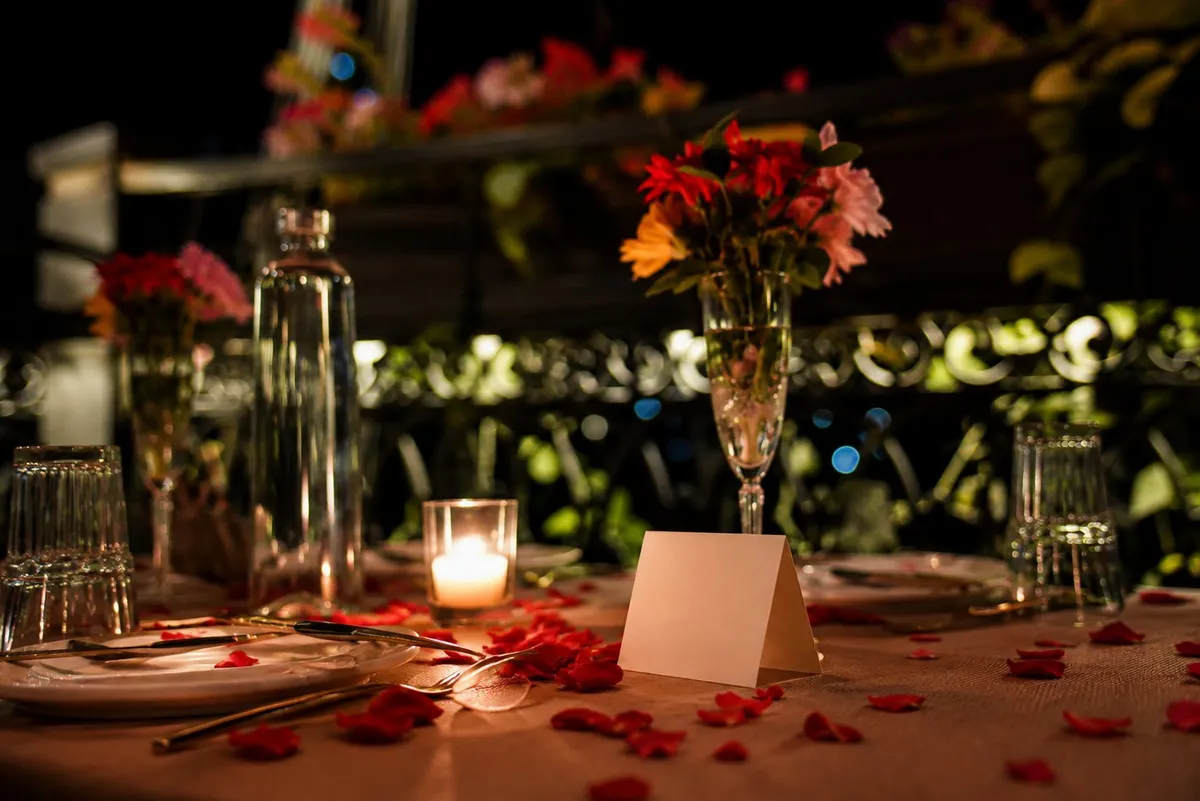 Table décor with rose petals and candles at blue hour